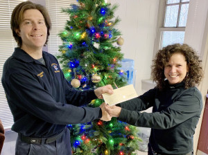 AIDING THE HOMELESS: Local 888 chapter chair Teri Lambert, right, gives a check to Tom Deeg of the Mashpee Homeless for the Holidays fundraiser. 