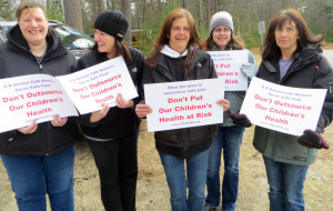 NOT BACKING DOWN: From left, Leslie Colt, Angela Gagne, Jane Cutts, Karen Nardone and Linda Mavilia hold signs April 10 in Groton as part of their successful campaign against outsourcing.
