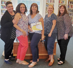SMILES ALL AROUND: Local 888 members Carol Hamilton, internal organizer Madeline Soto, Sue Noel, Kerry Lee-Noel and Cynthia Alexander celebrate the Dracut chapter’s new contract. 