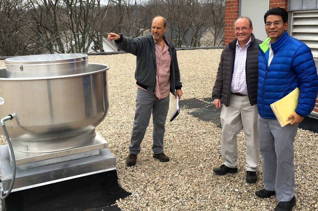 Jorge Vargas and other members of the P&E team inspect new vents installed on the roof of the Washington Irving School. 