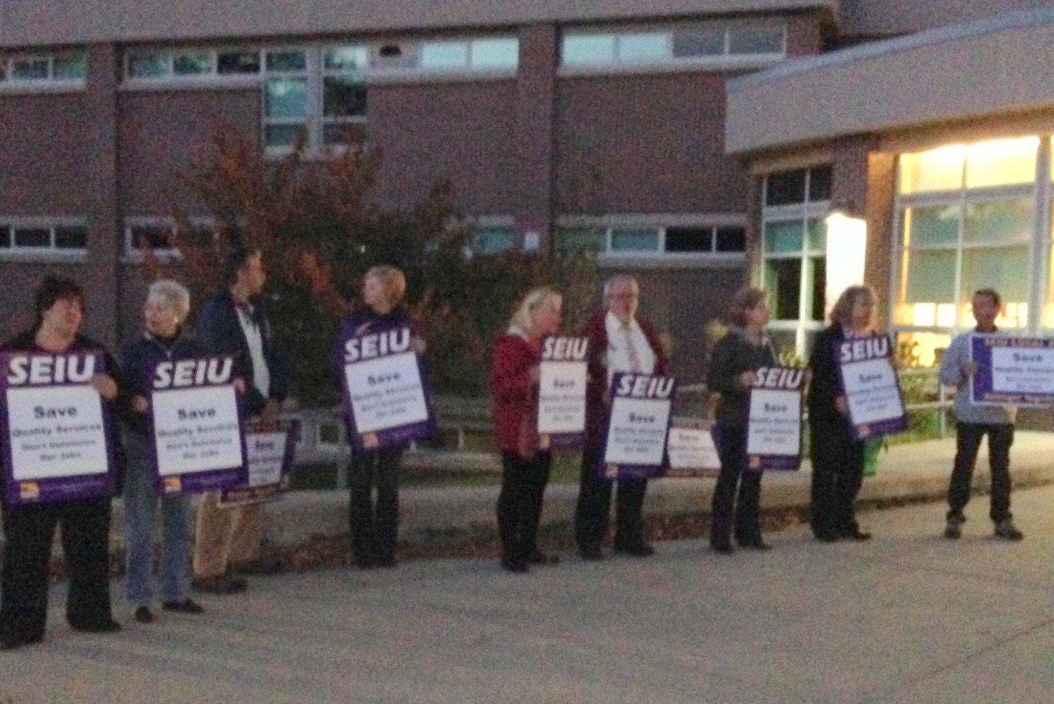 Members holding signs at Westborough town meeting