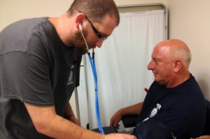 Nurse Peter Lanceleve practices his skills on Rick Moffatt at the Chelsea Soldier’s Home. Working at the home has been a Lanceleve family tradition for 90 years.